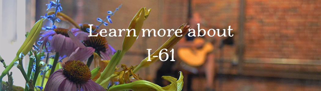 Flower bouquet closeup with blurred guitarist in front of brick wall, reads Learn more about I-61 
